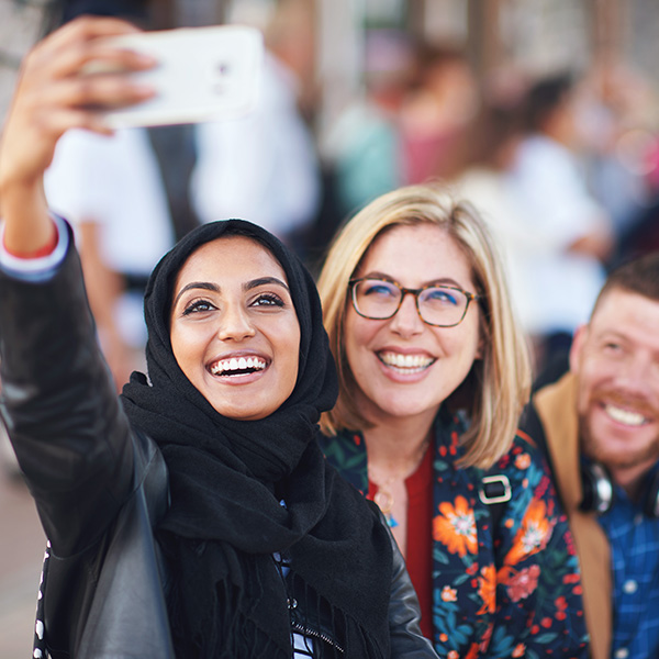 happy-muslim-woman-taking-photo-with-friends